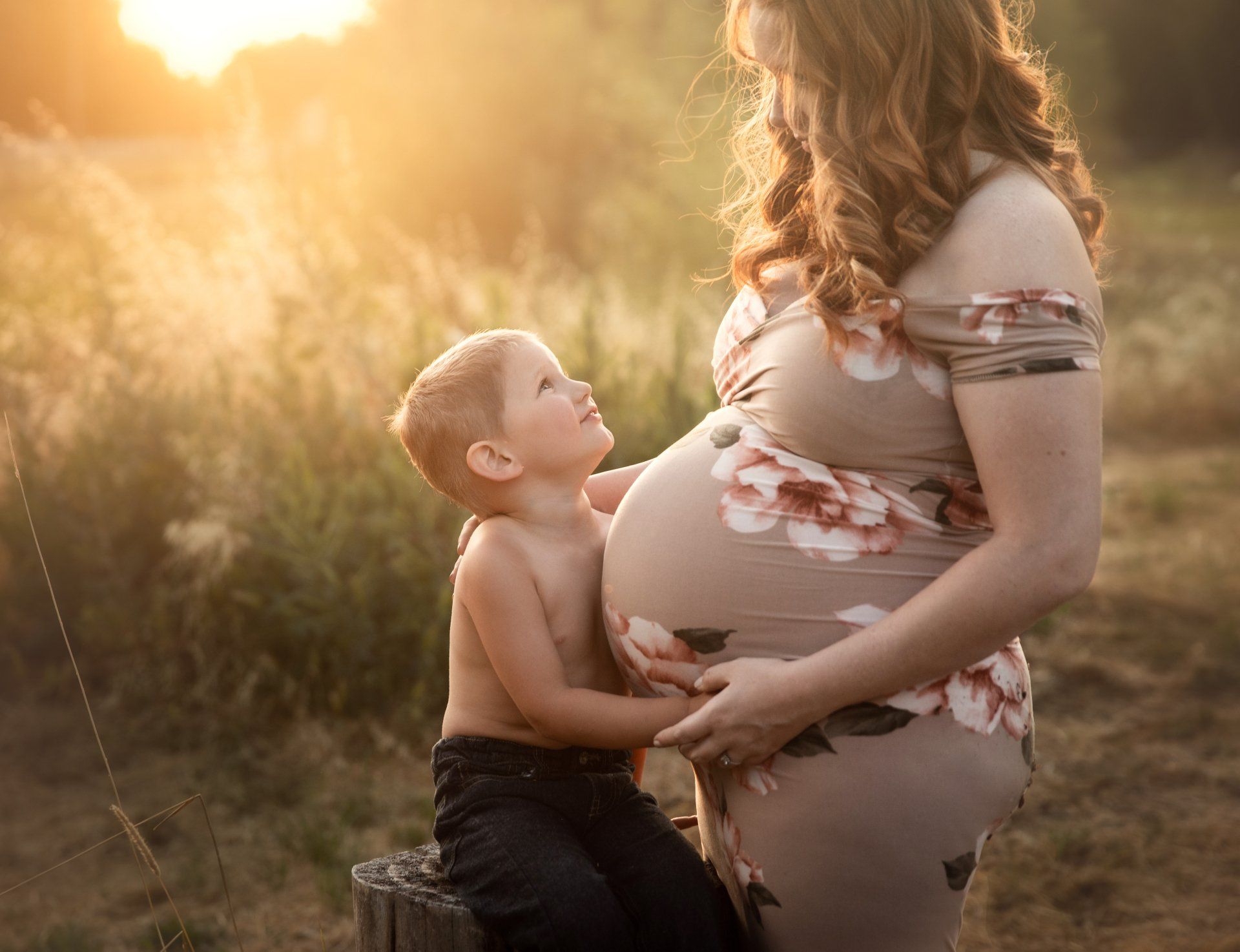 A pregnant woman is standing next to a young boy. Maternity Photos