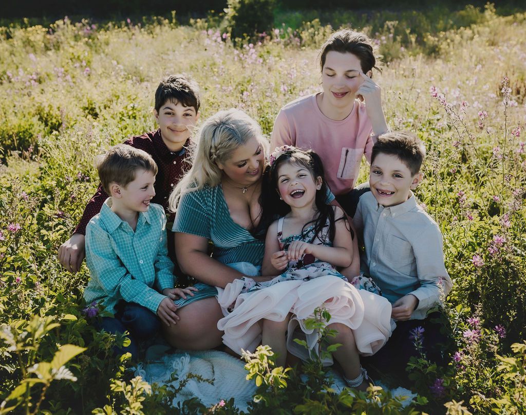 A family is sitting in a field of flowers.