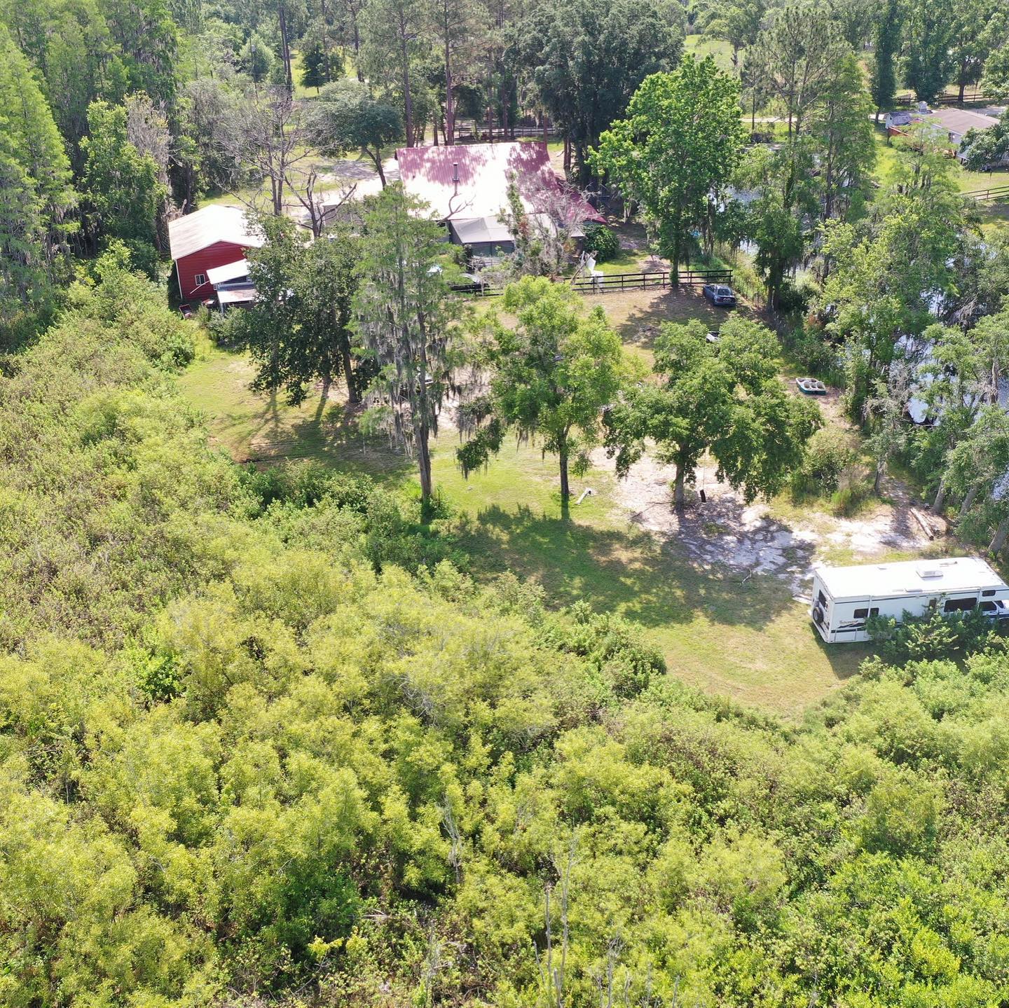 an aerial view of a house surrounded by trees and bushes .