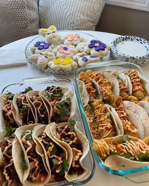 A table topped with a variety of food including tacos and cookies.