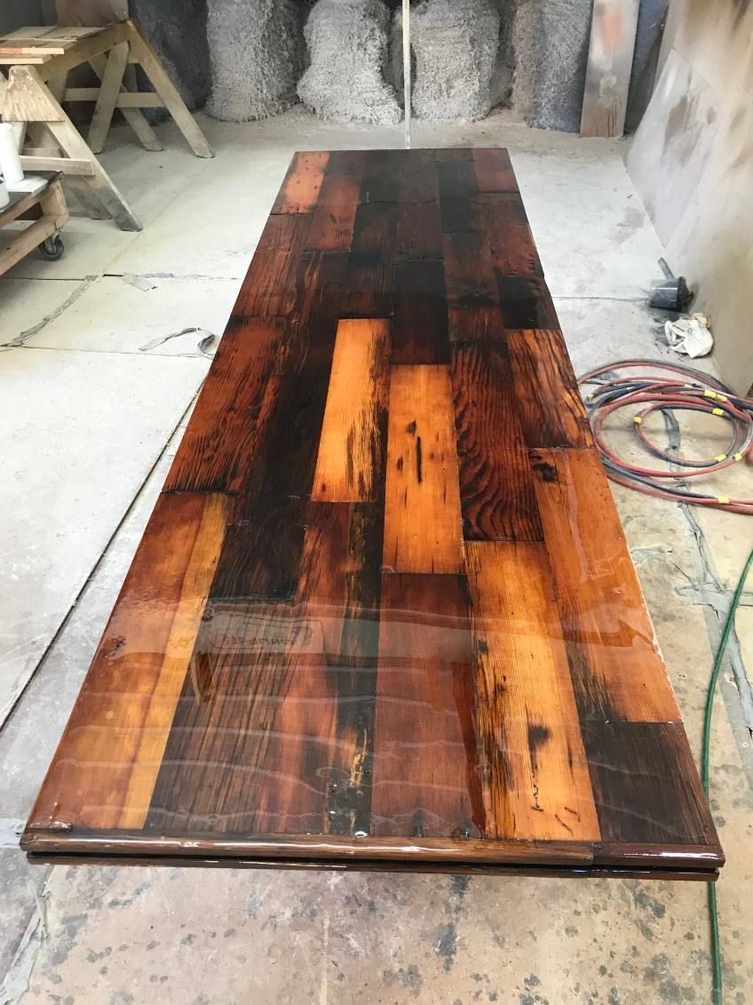 Long, rectangular, wooden table with shiny, dark, varnished surface.