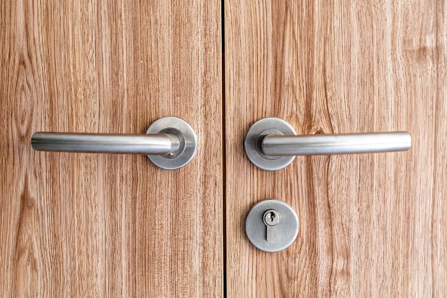 Wooden double doors with silver handles and a keyhole. Wooden double doors with silver handles and a keyhole.