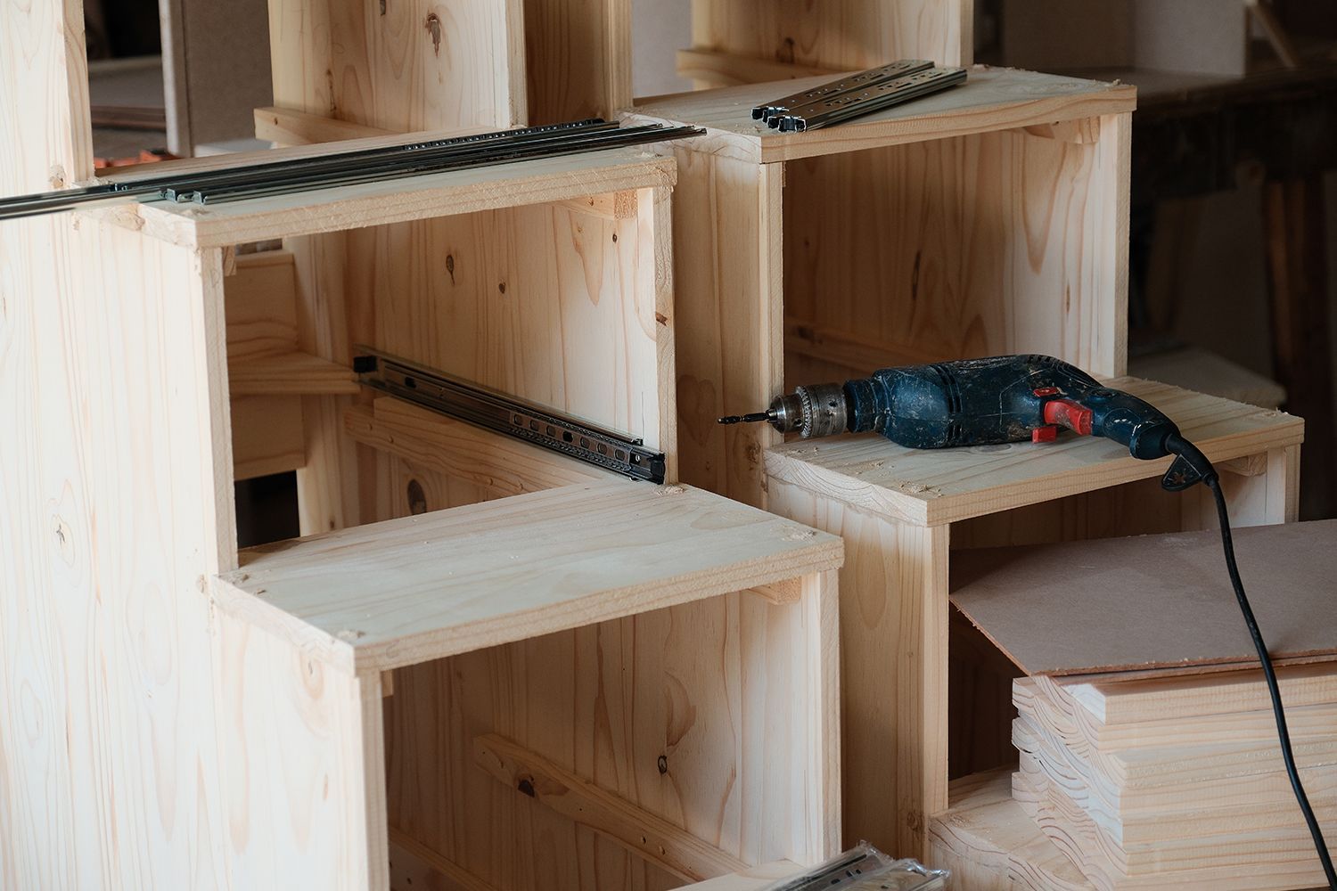 Wooden cubby structures under construction with a drill and model train tracks. Wooden cubby structures under construction with a drill and model train tracks.