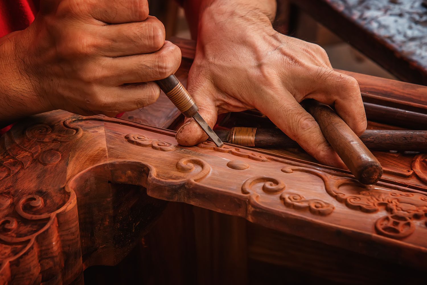 Hands carving wood with chisels, detail view. Brown wood and tools. Hands carving wood with chisels, detail view. Brown wood and tools.