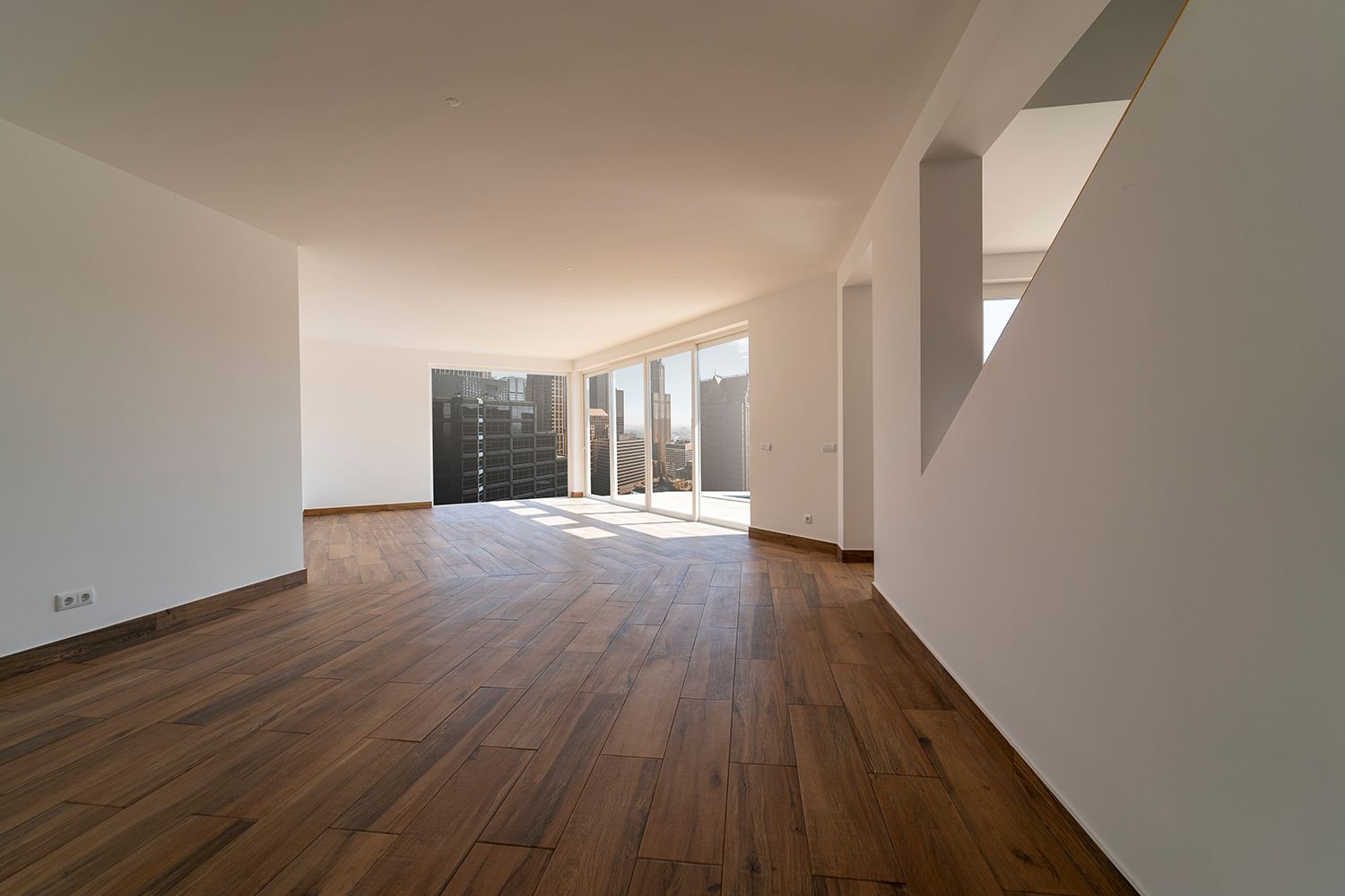 Empty room with hardwood floors, white walls, and large windows. Empty room with hardwood floors, white walls, and large windows.