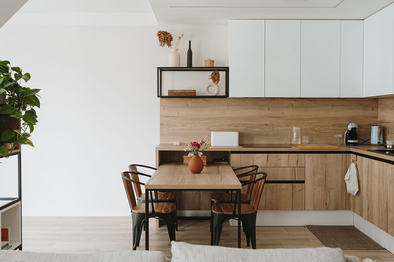 Modern kitchen with wooden cabinets, dining table, and built-in shelving. Modern kitchen with wooden cabinets, dining table, and built-in shelving.