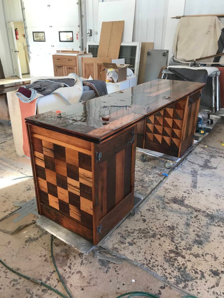 Wooden bar with checkerboard and geometric patterns, in a workshop setting.