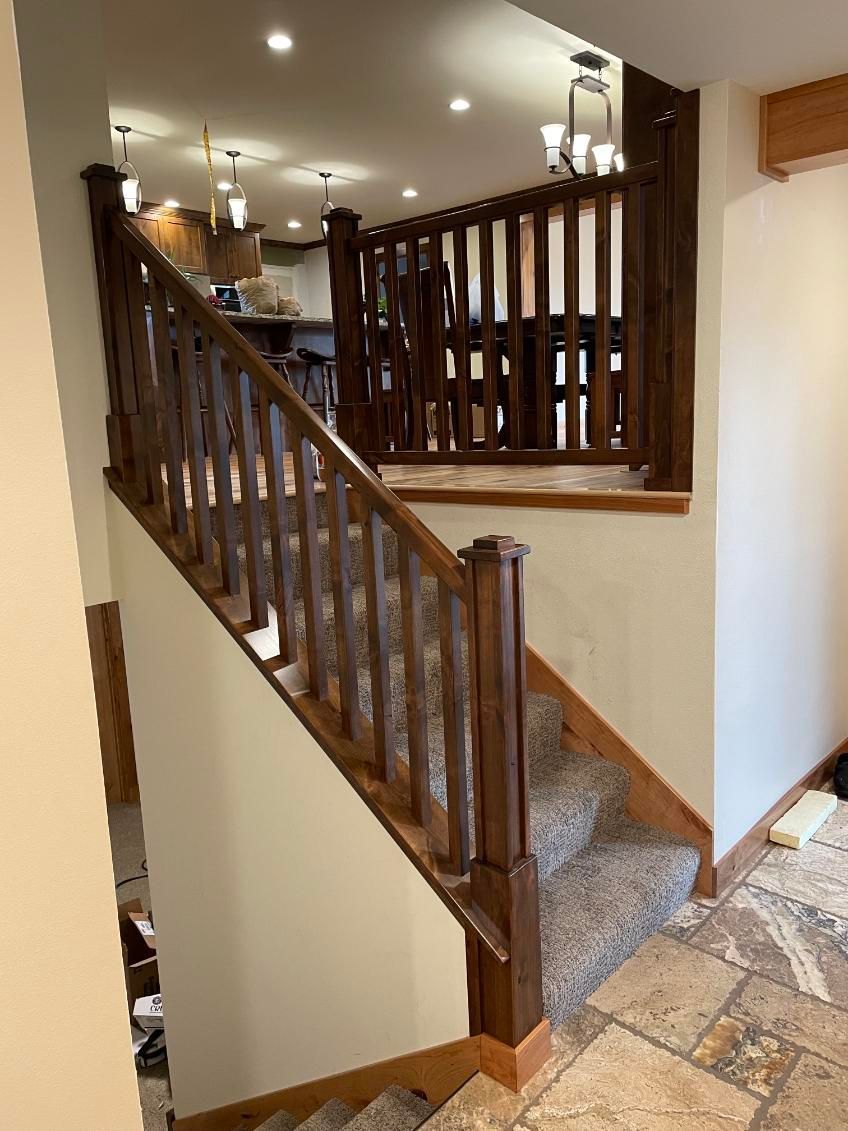 Wooden staircase with carpeted steps leading to a landing with a gate, in a home. Wooden staircase with carpeted steps leading to a landing with a gate, in a home.