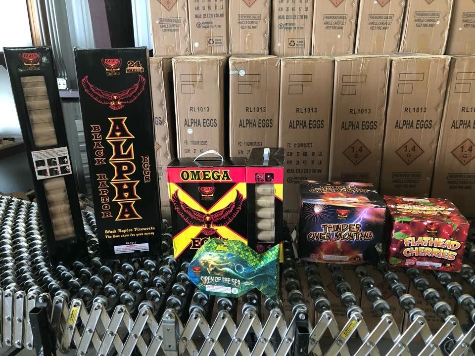 Boxes of fireworks are stacked on top of each other in a warehouse.