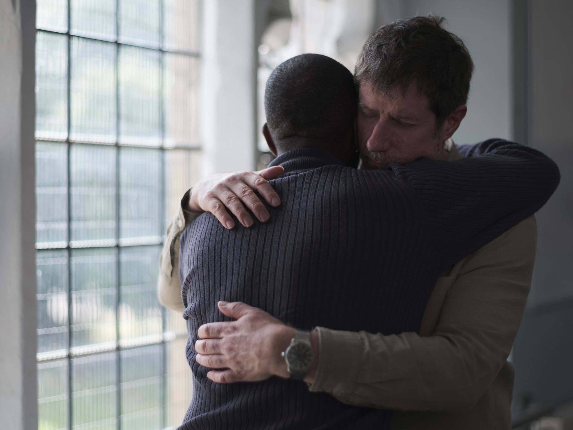 two men hugging in grief