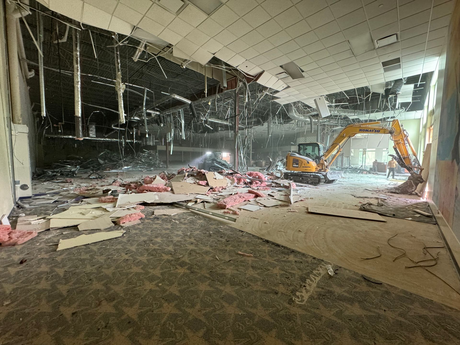 A large building is being demolished by a bulldozer.