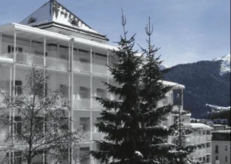 Ein Schwarzweißfoto eines Gebäudes mit einem Weihnachtsbaum davor