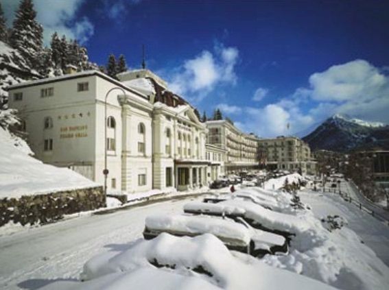 Ein großes weißes Gebäude ist von Schnee und Bergen umgeben