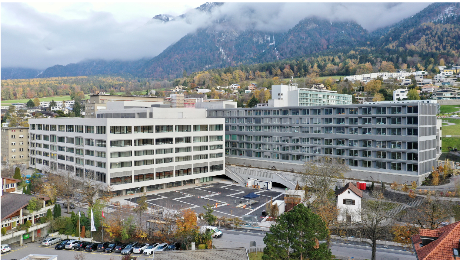 Eine Luftaufnahme eines großen Gebäudes mit Bergen im Hintergrund.