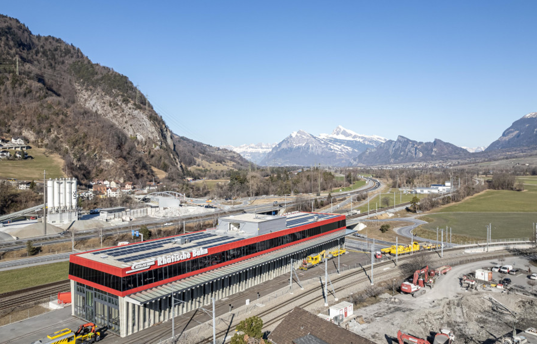 Eine Luftaufnahme eines Gebäudes inmitten eines Tals mit Bergen im Hintergrund.