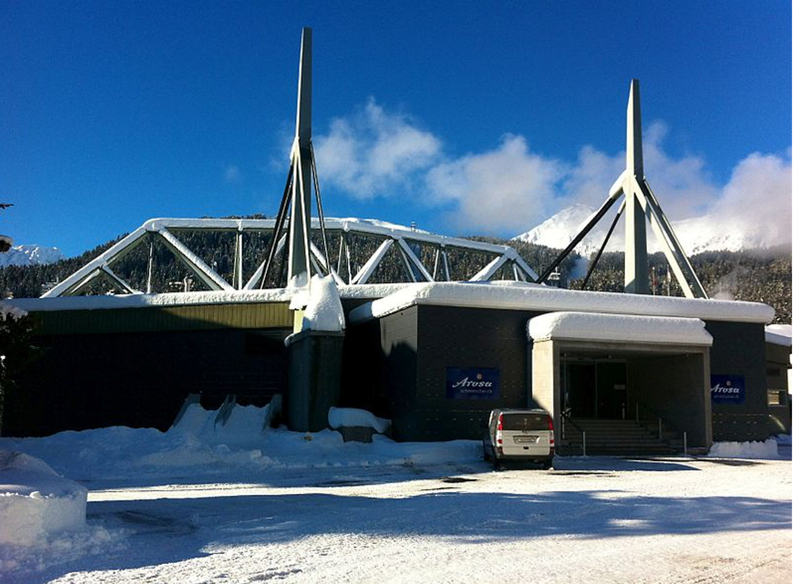 Ein Auto ist vor einem schneebedeckten Gebäude geparkt