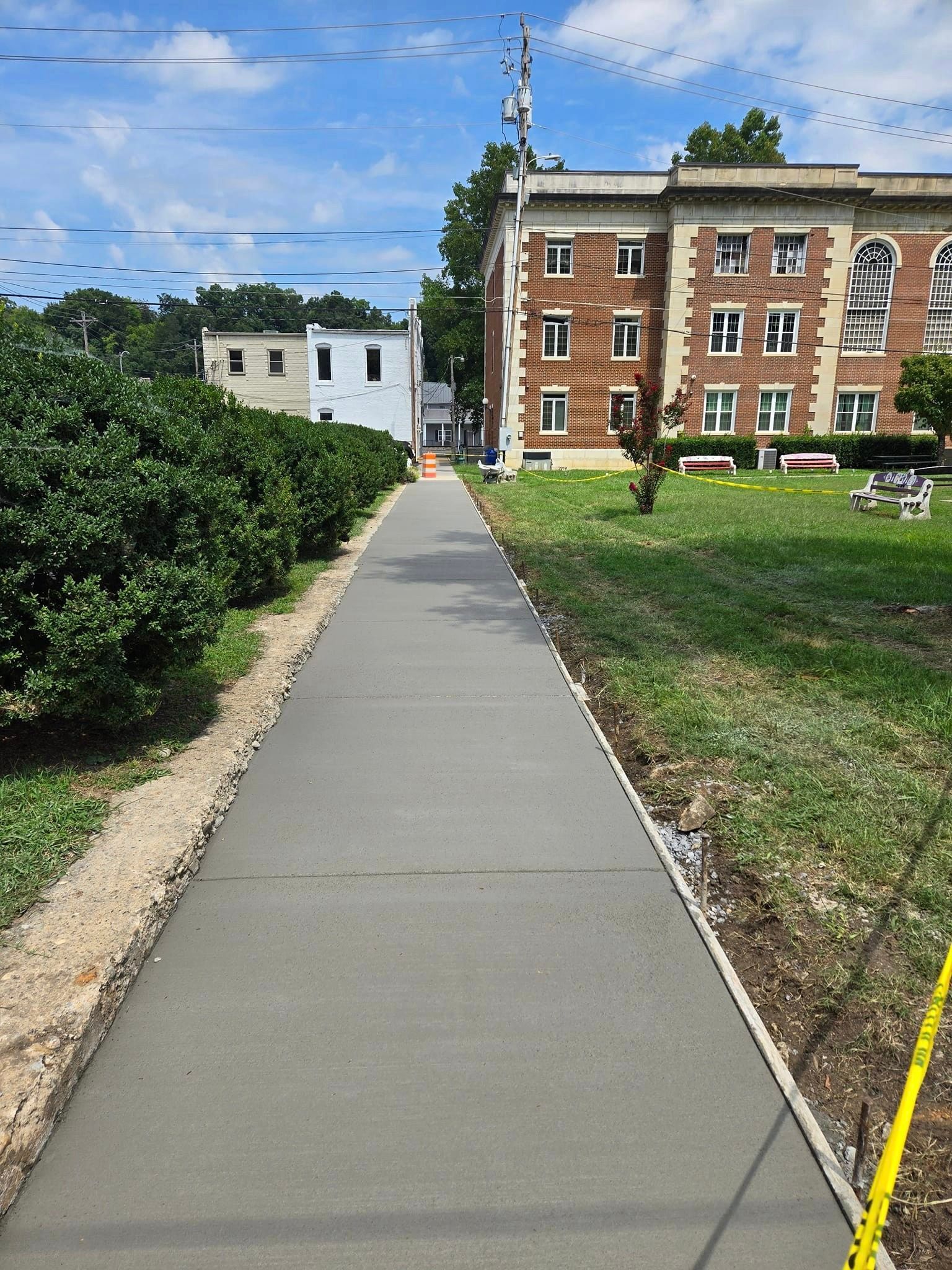 A concrete walkway leading to a large brick building