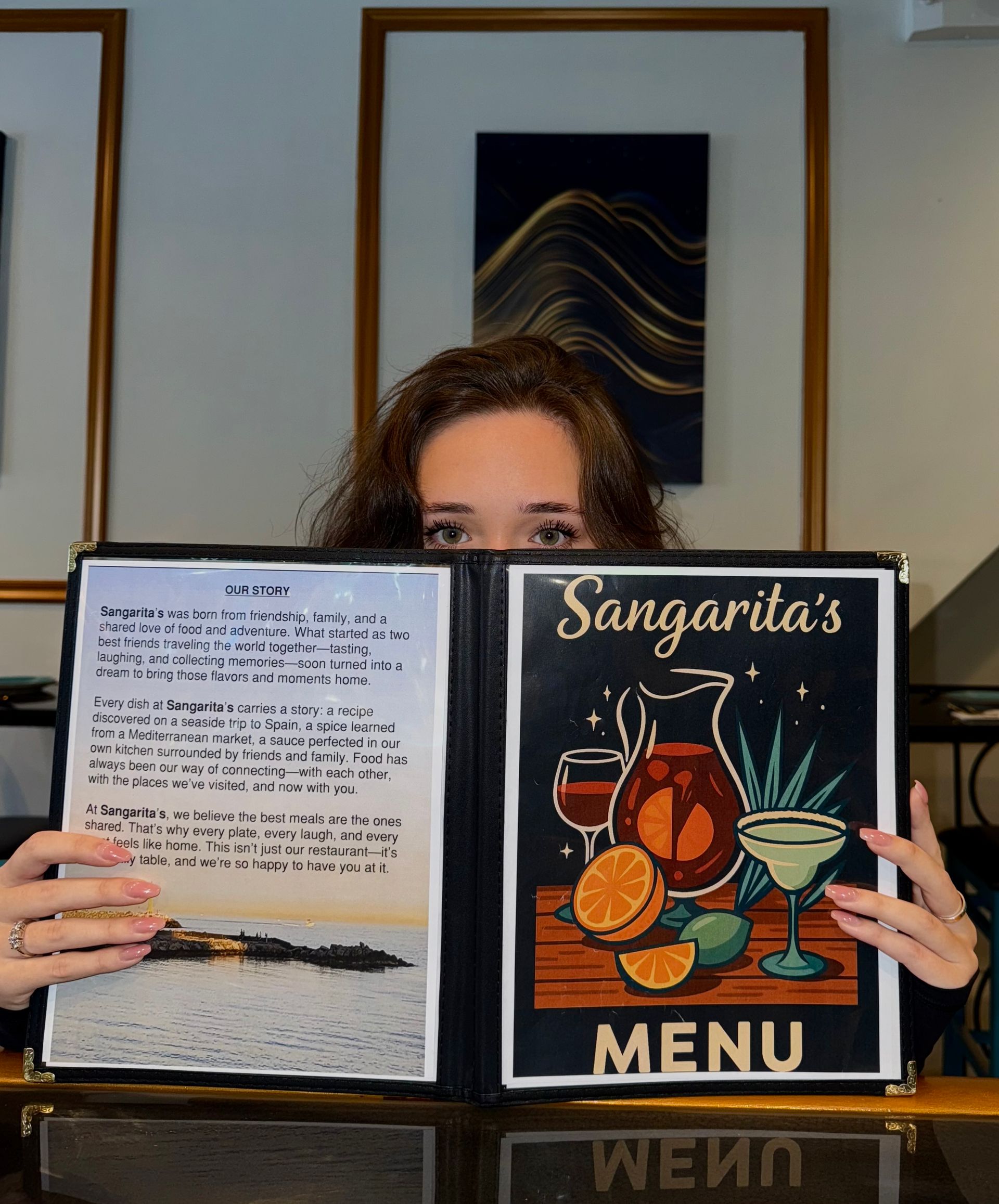 Woman holding Sangarita's restaurant menu, showing a colorful drinks design and menu text.
