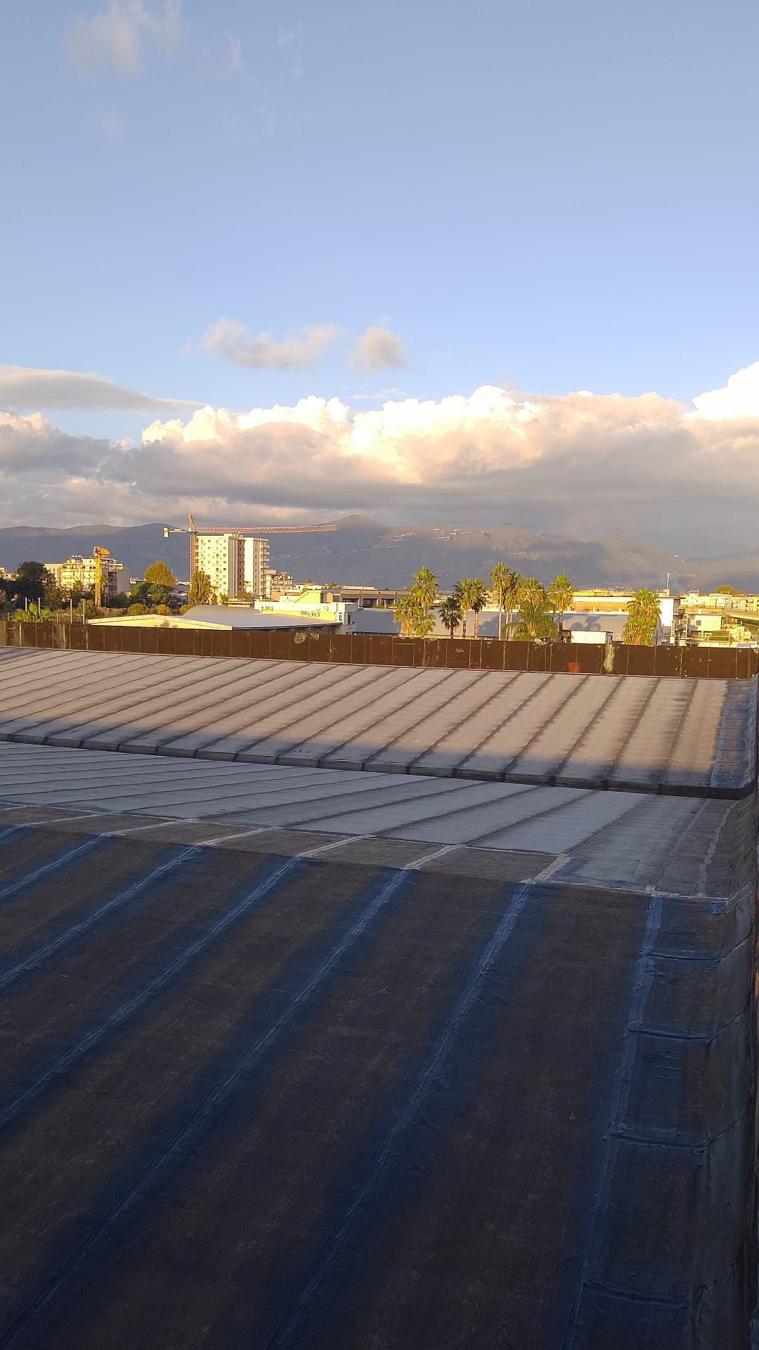 Un grande tetto con vista sulla città e sulle montagne sullo sfondo.