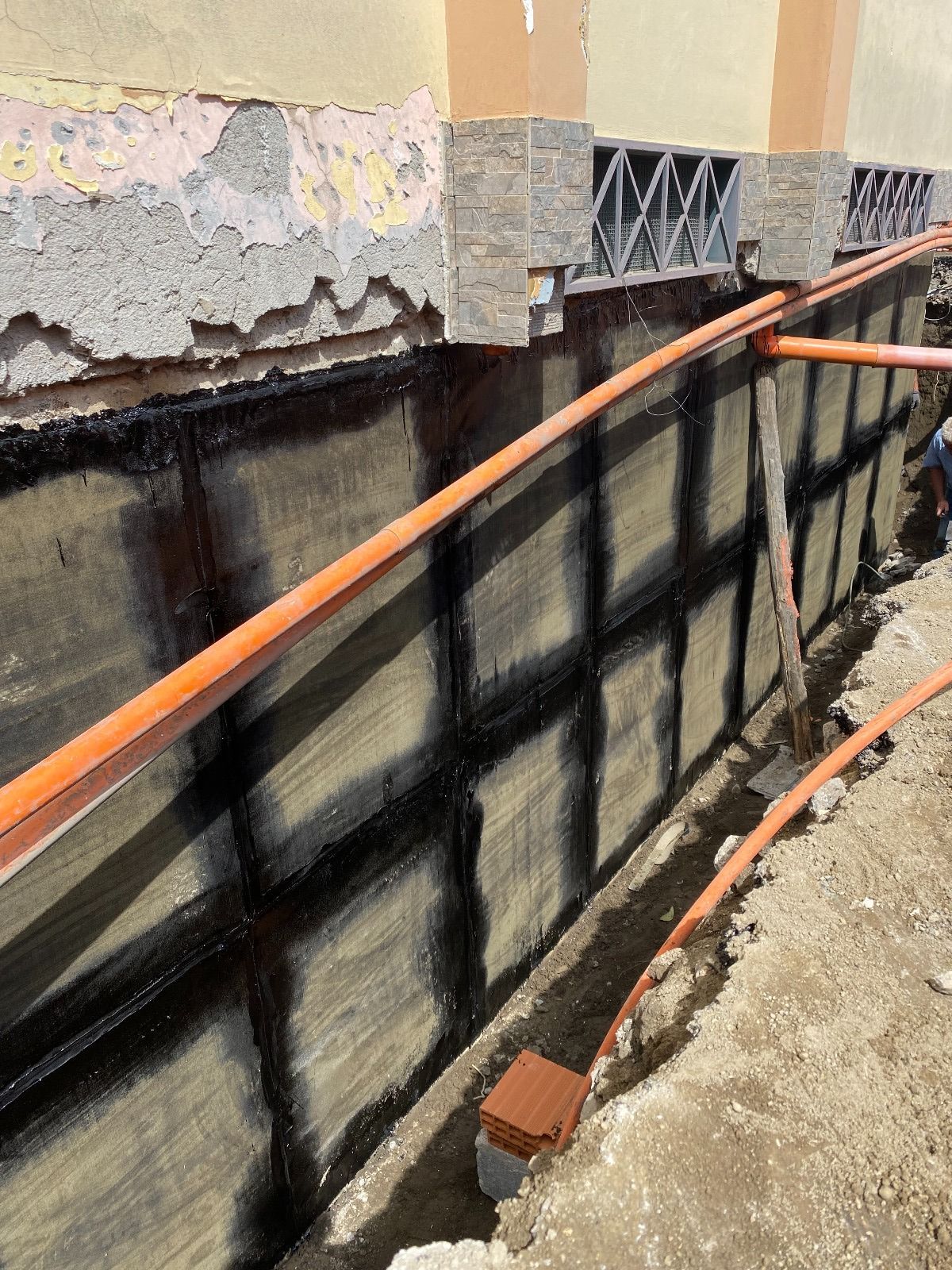 Un sistema di drenaggio viene installato sul lato di un edificio.