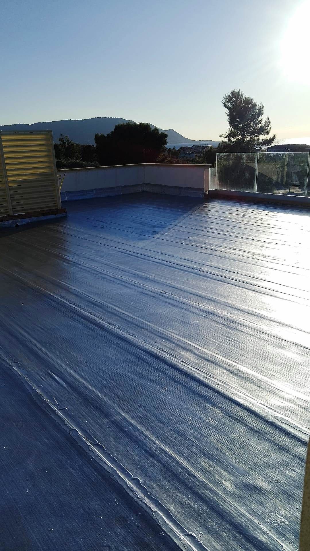 Un tetto con un telo blu e montagne sullo sfondo.