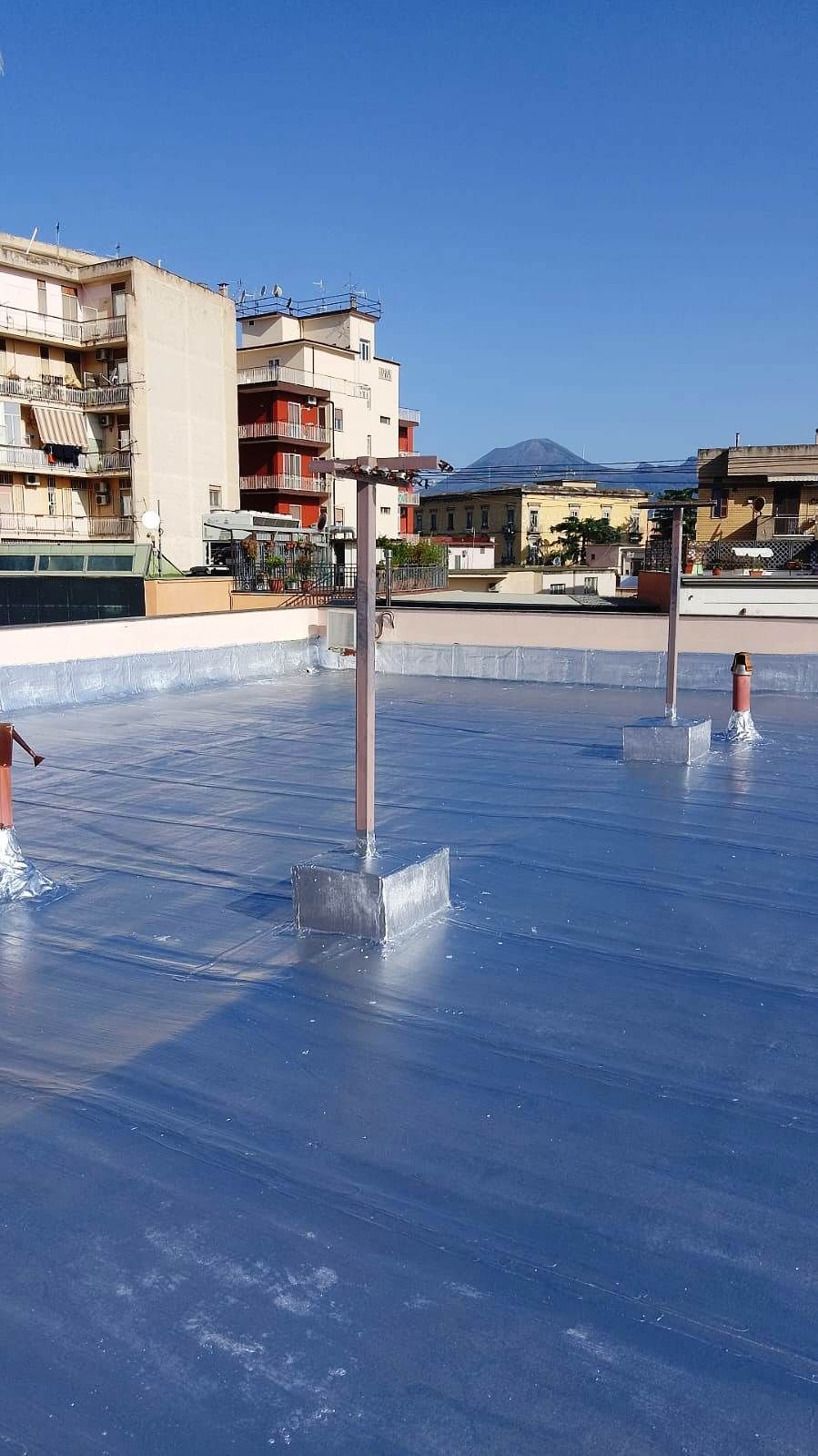 Un tetto con un sacco di tubi e degli edifici sullo sfondo.