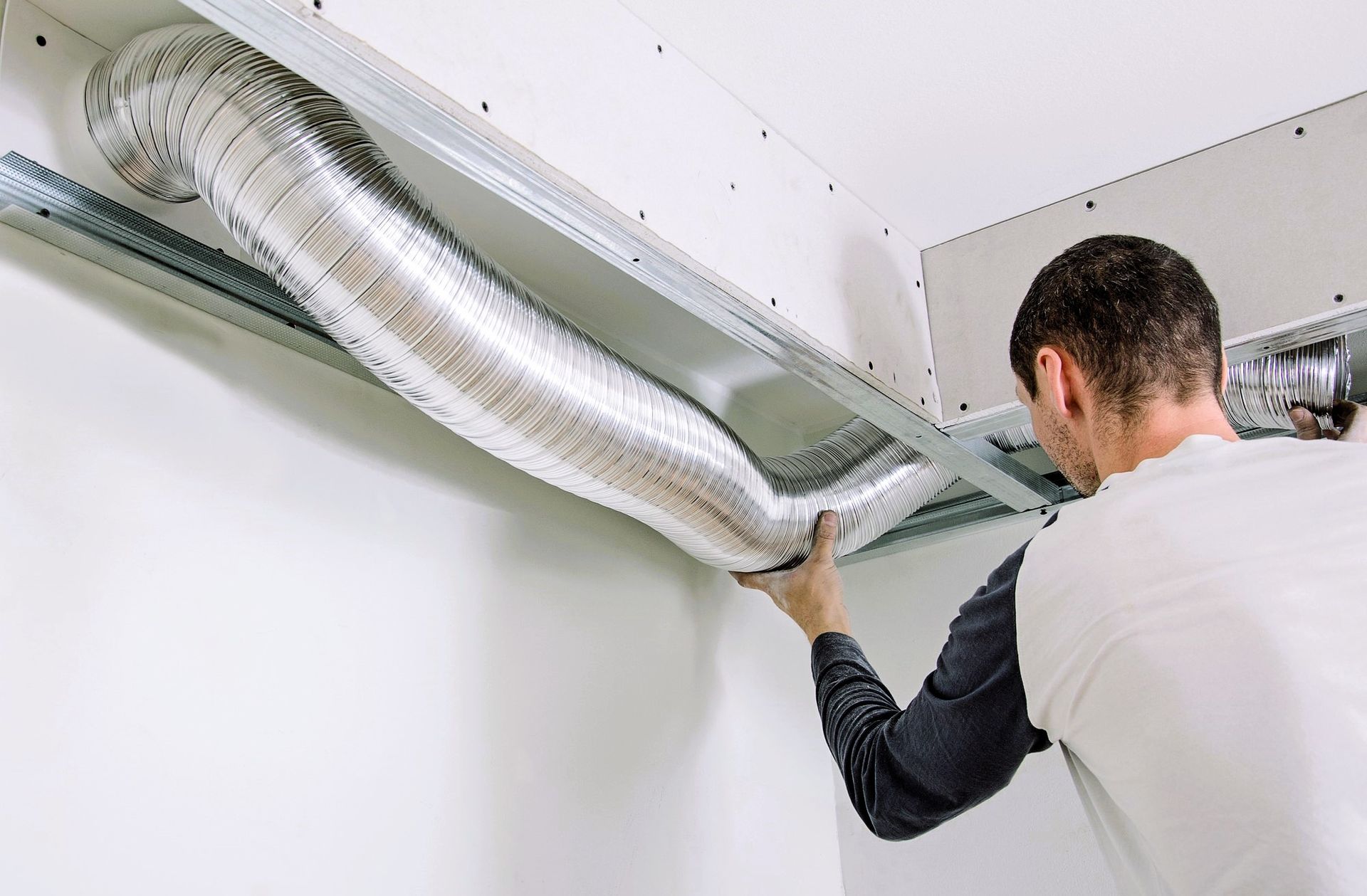 Man inspecting duct ventilation seal for quality and efficiency