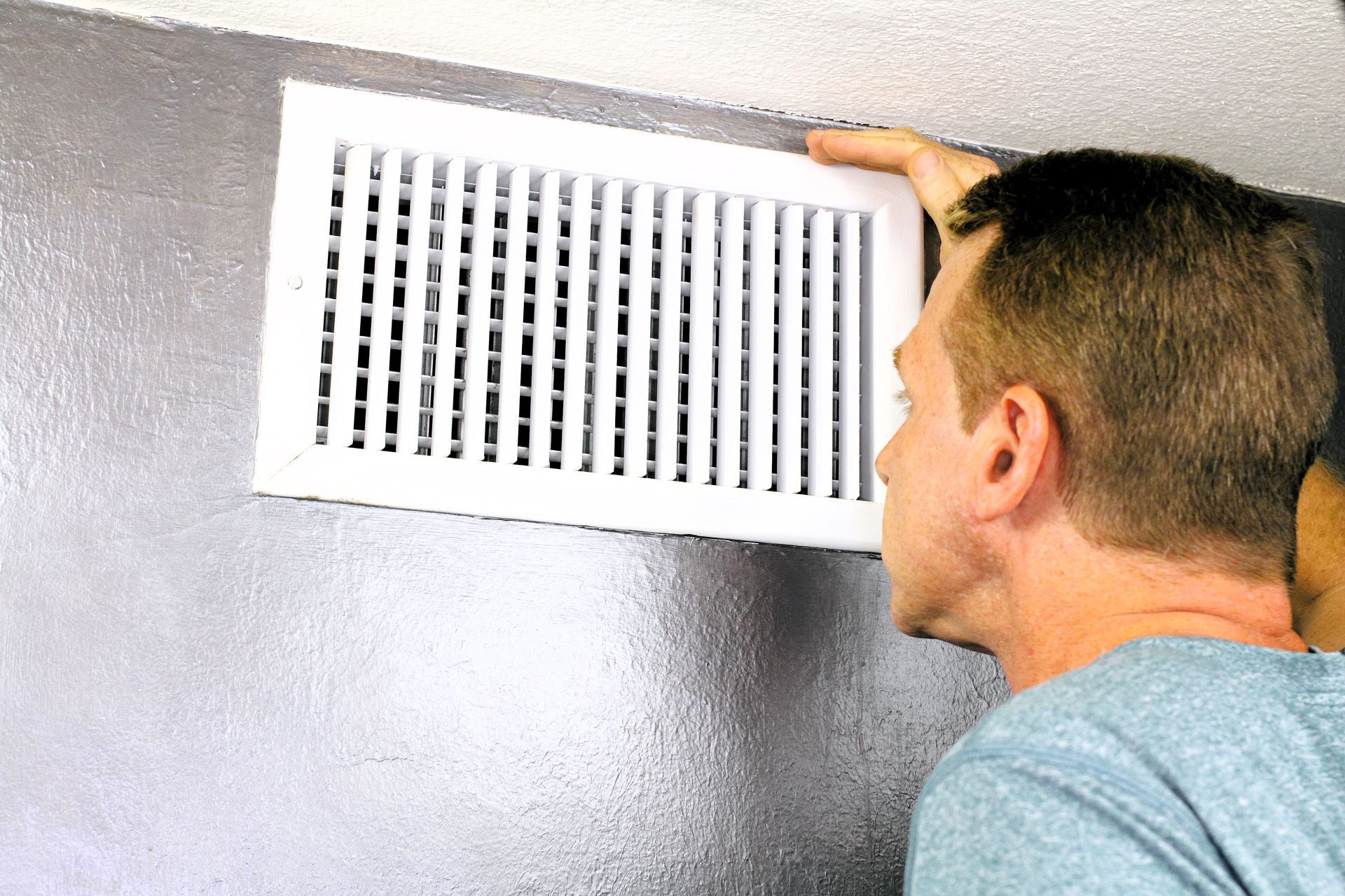 Expert inspecting home air vent for maintenance