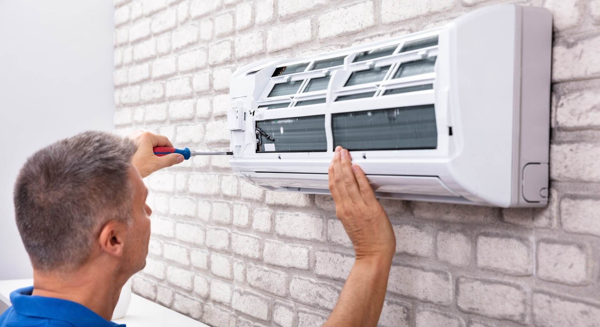 Man fixing his air conditioner with a common issue