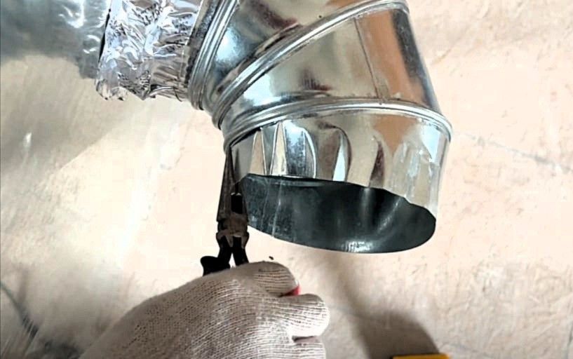 HVAC technician using duct crimpers to adjust metal duct fitting during air duct repair