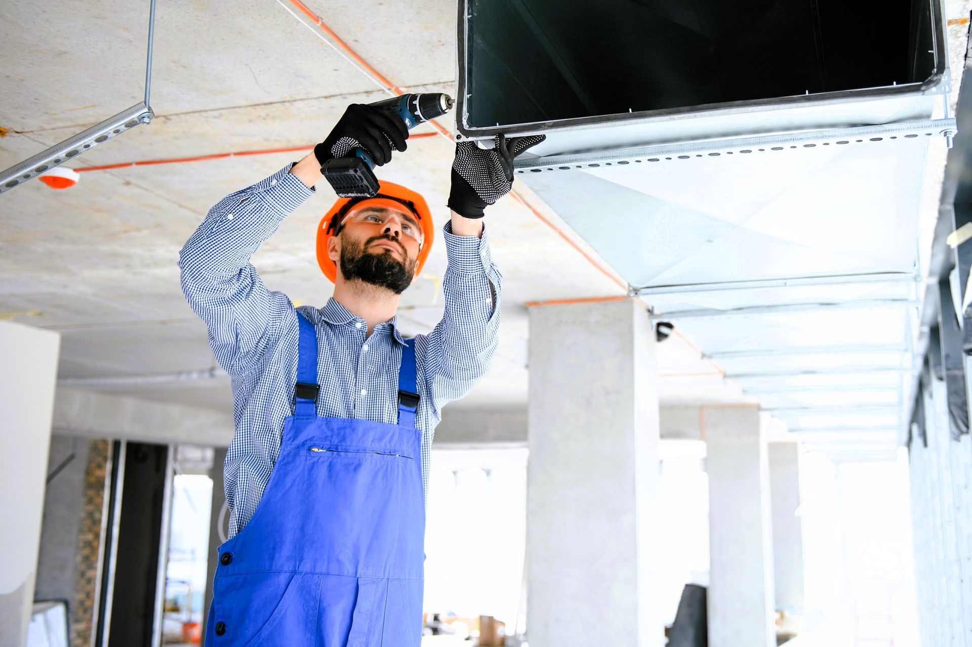 Professional installing air duct on a ceiling as part of ductwork replacement in a residential home