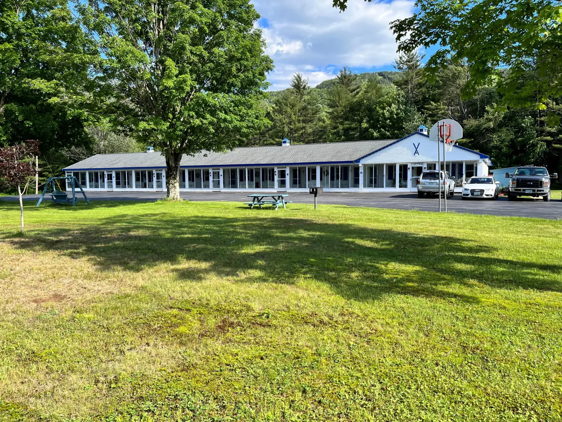 A large house is sitting in the middle of a lush green field.