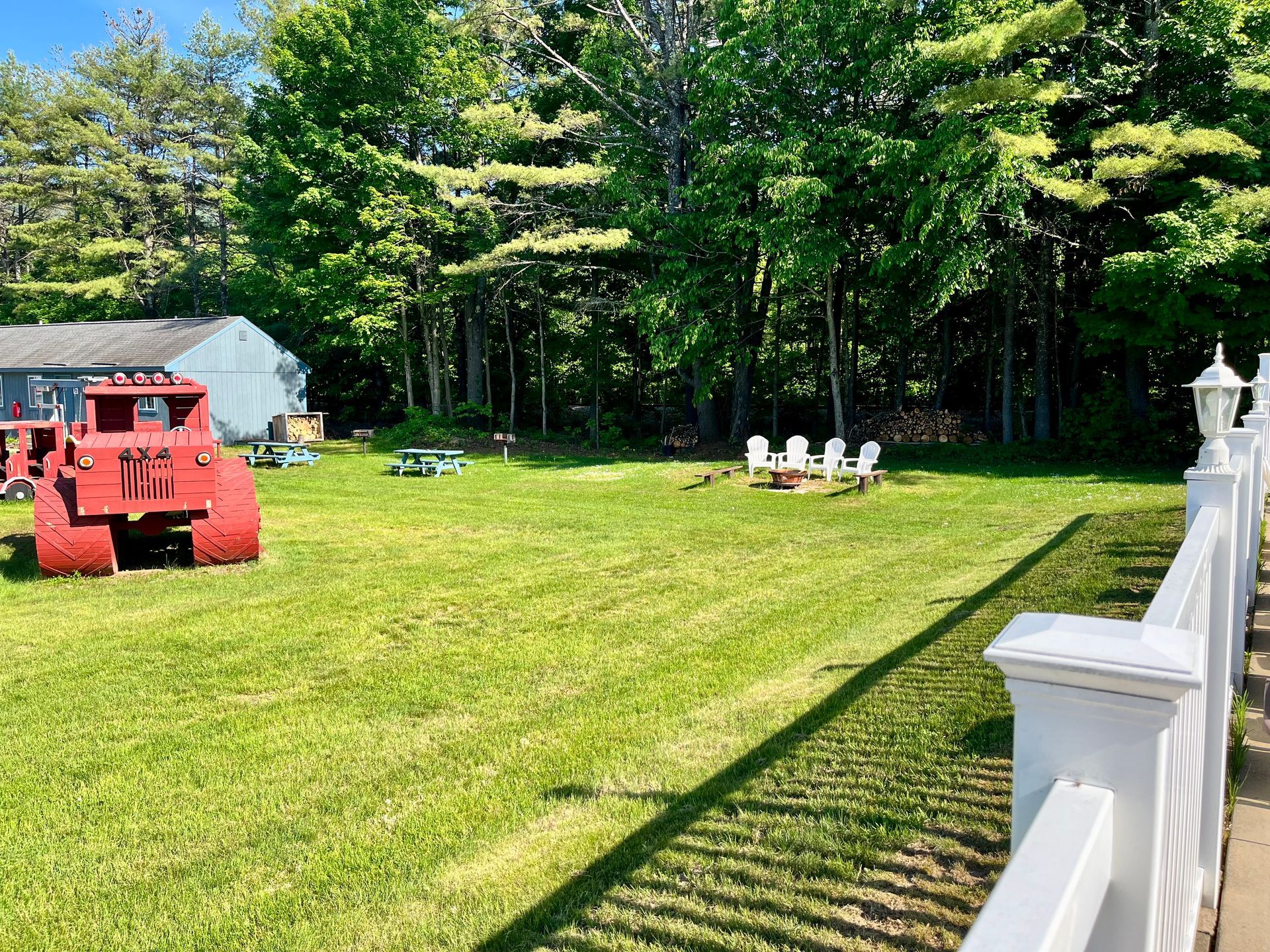 A red bulldozer is parked in the middle of a lush green field.