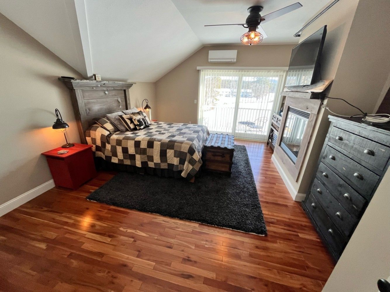 A bedroom with a bed , dresser , nightstand and television.