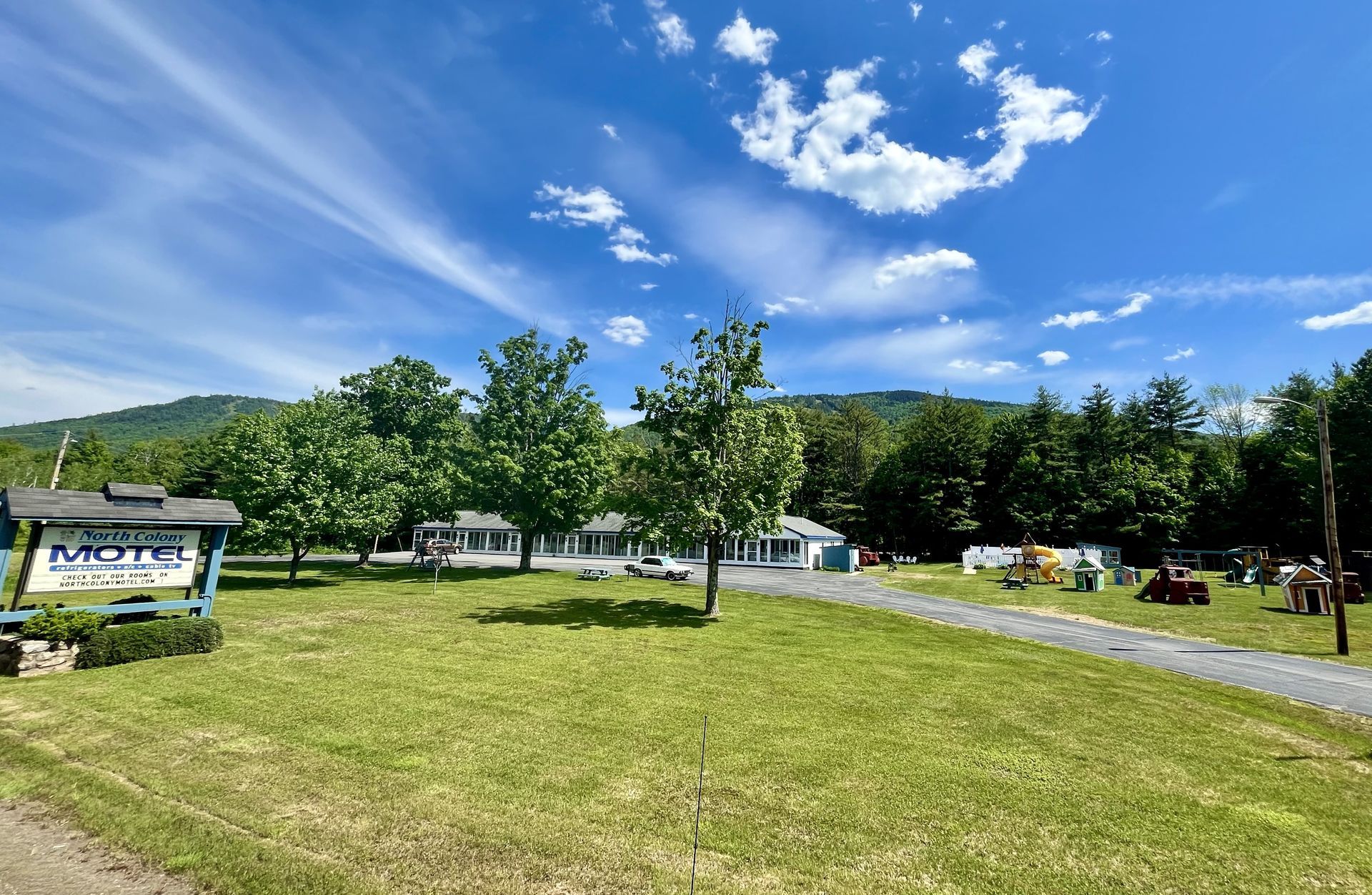 A large grassy field with a motel in the background.