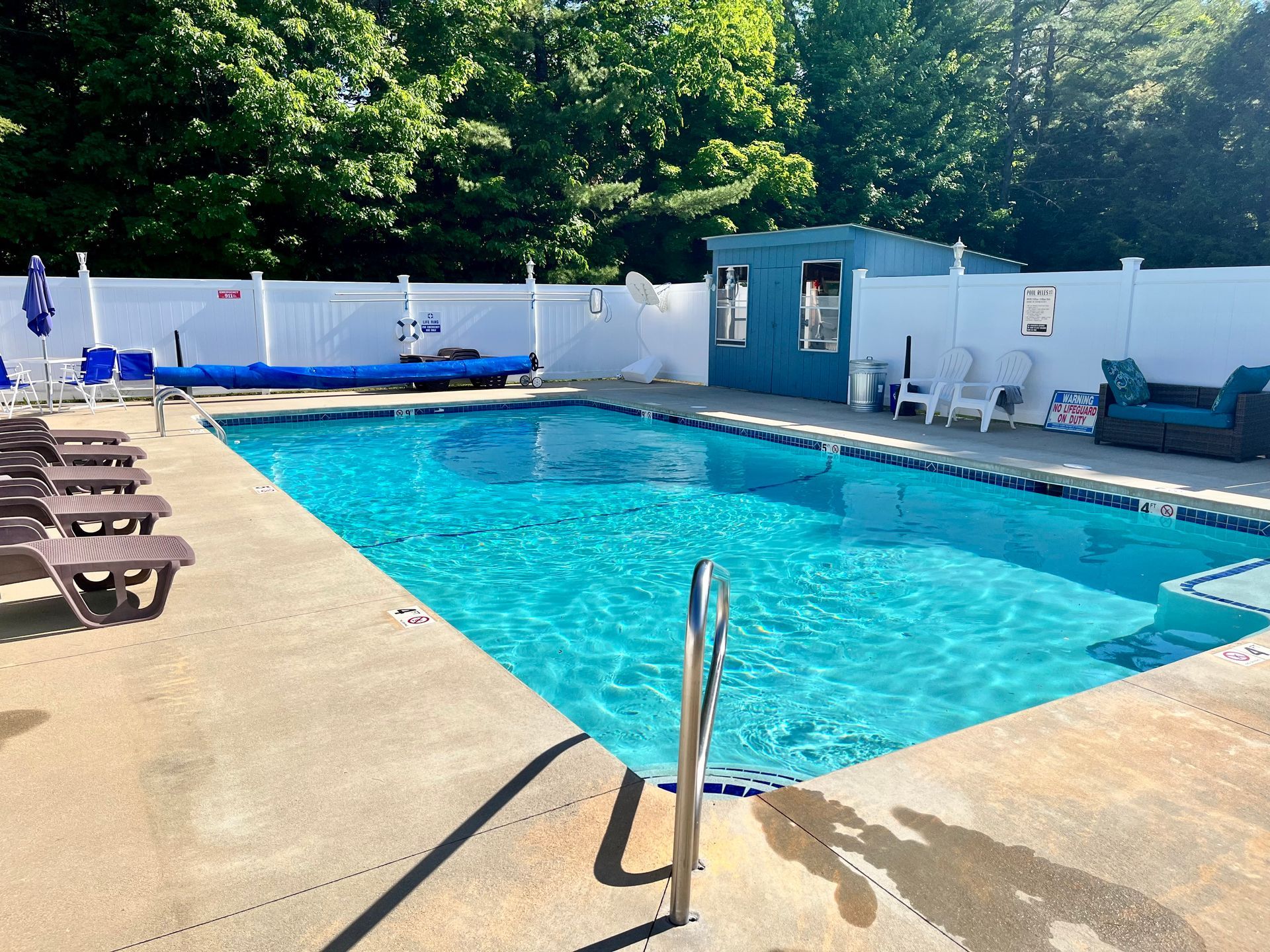A large swimming pool with a white fence around it