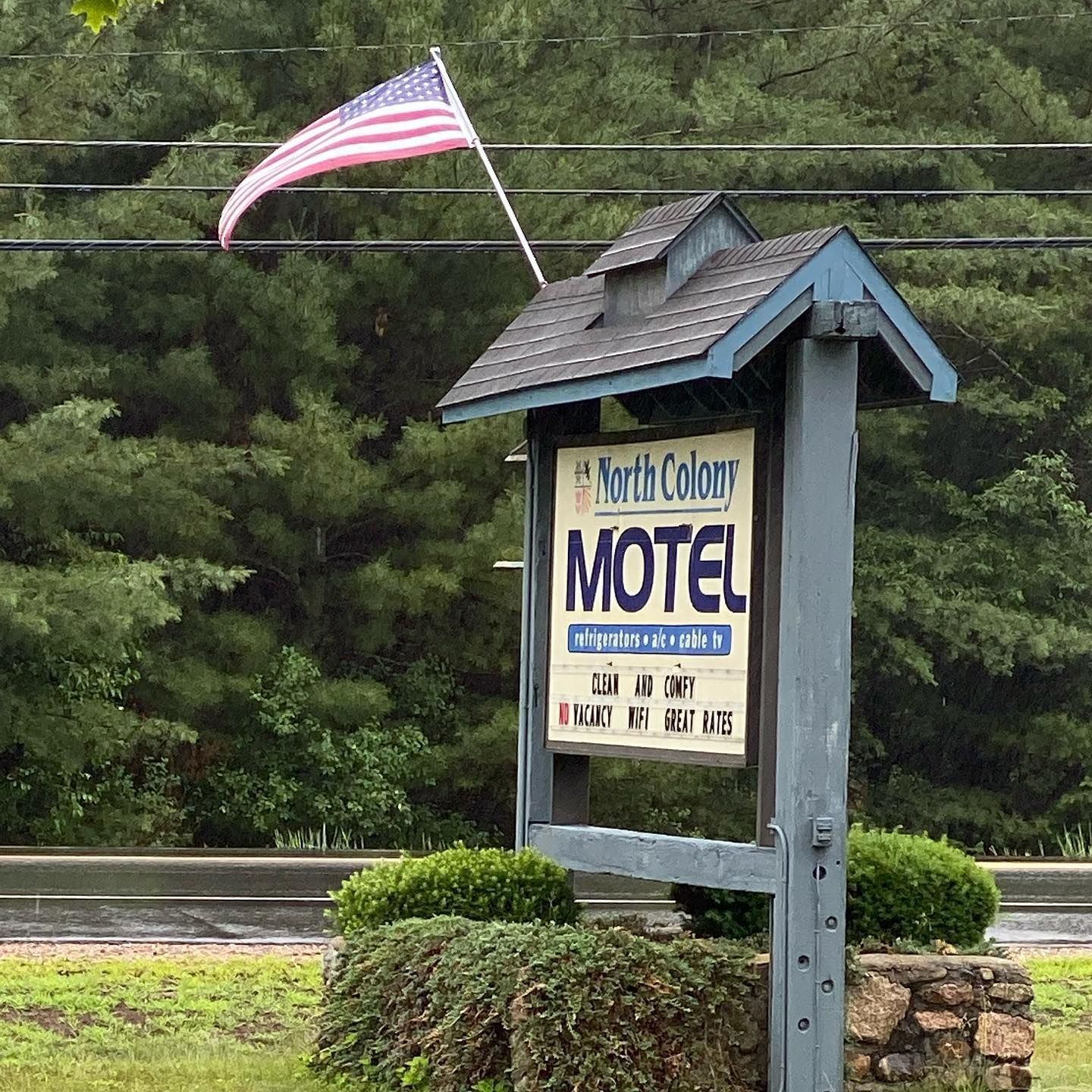 A motel sign with an american flag in the background