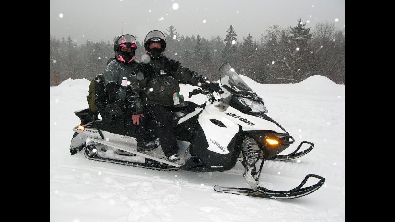 Two people are riding a snowmobile in the snow