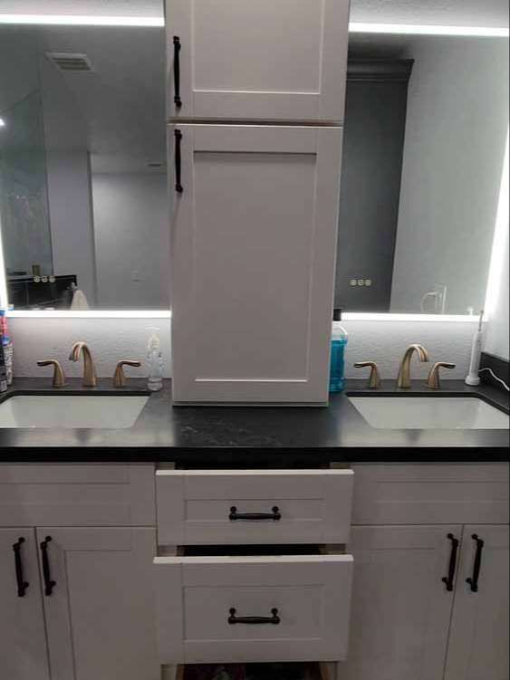 A bathroom with two sinks and a mirror.