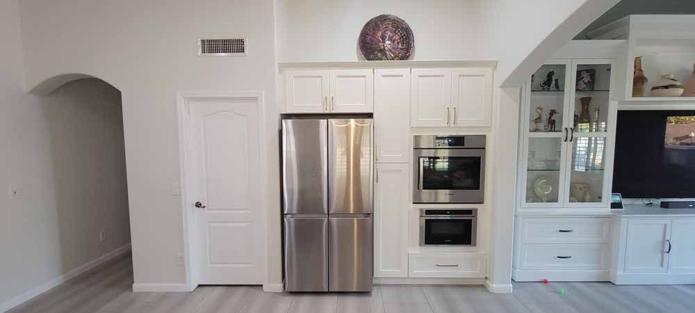 A kitchen with stainless steel appliances and white cabinets.