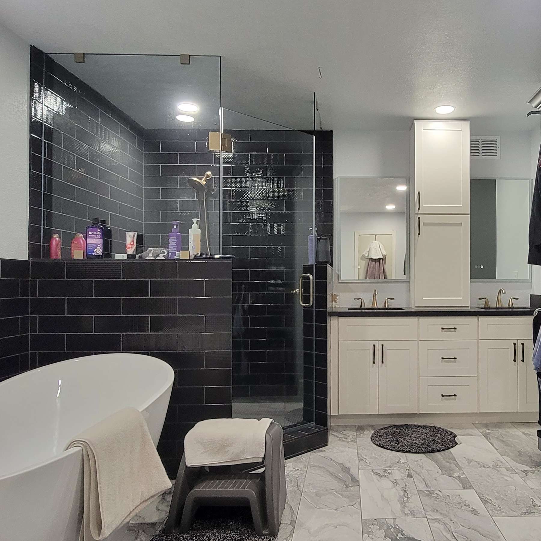 A bathroom with a tub and a walk in shower.