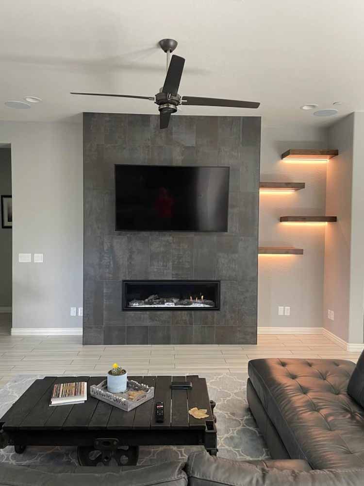 A living room with a fireplace and a flat screen tv on the wall.
