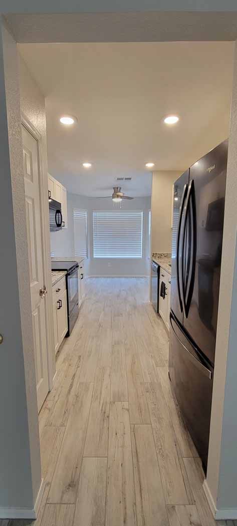 A kitchen with a refrigerator , microwave , and sink.
