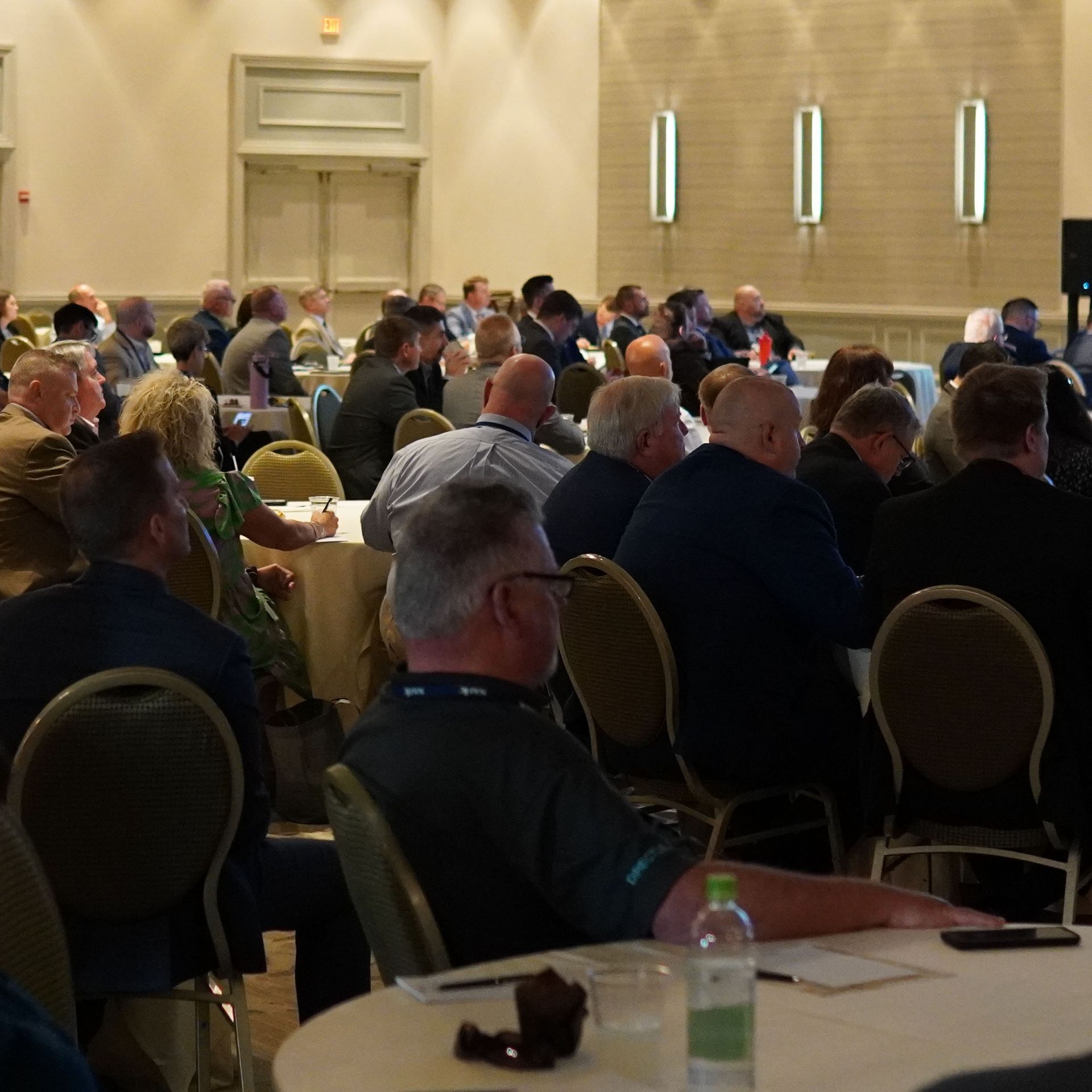 A large group of people are sitting at tables in a large room