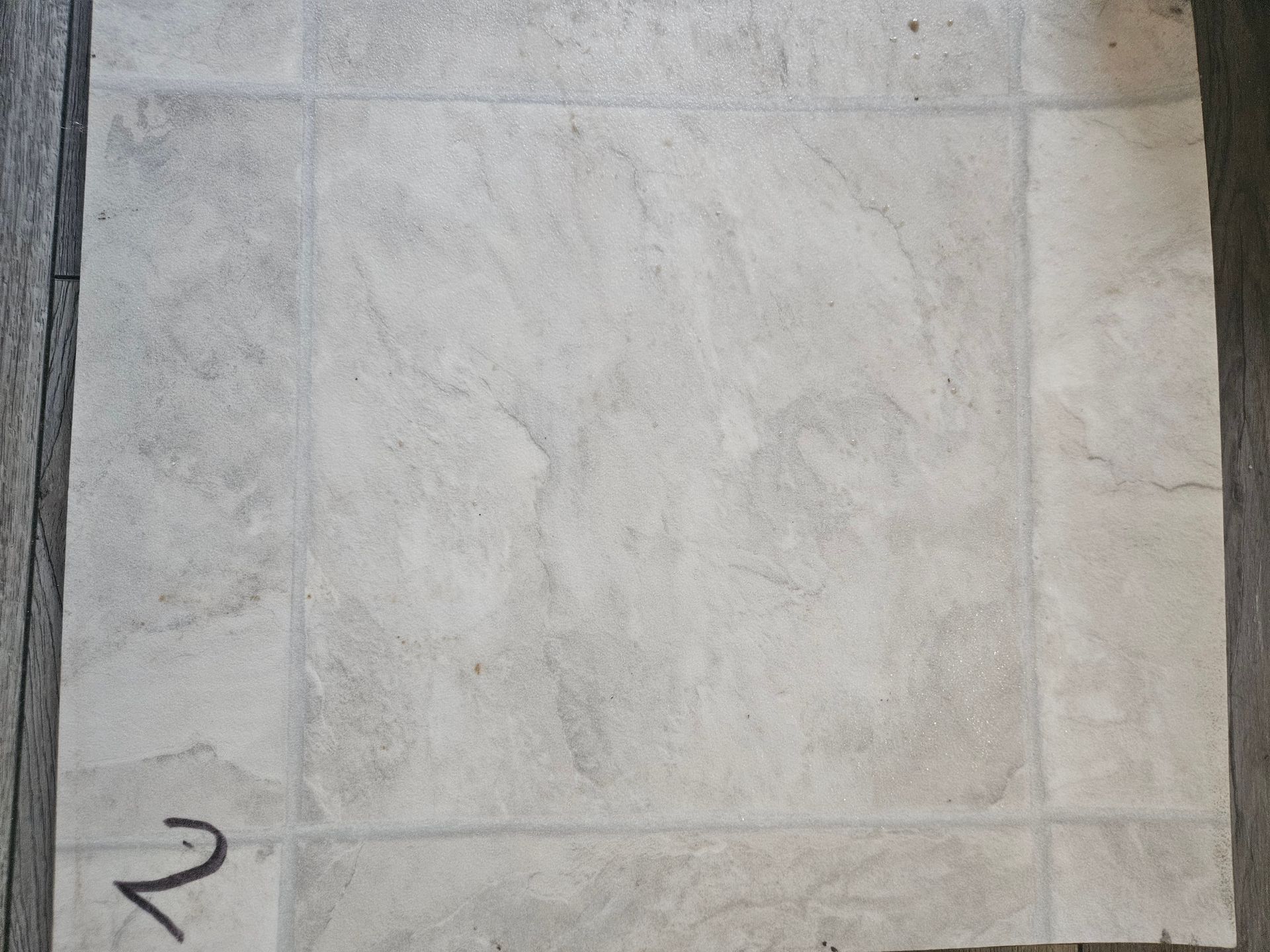 A close up of a tile floor with the letter n written on it.