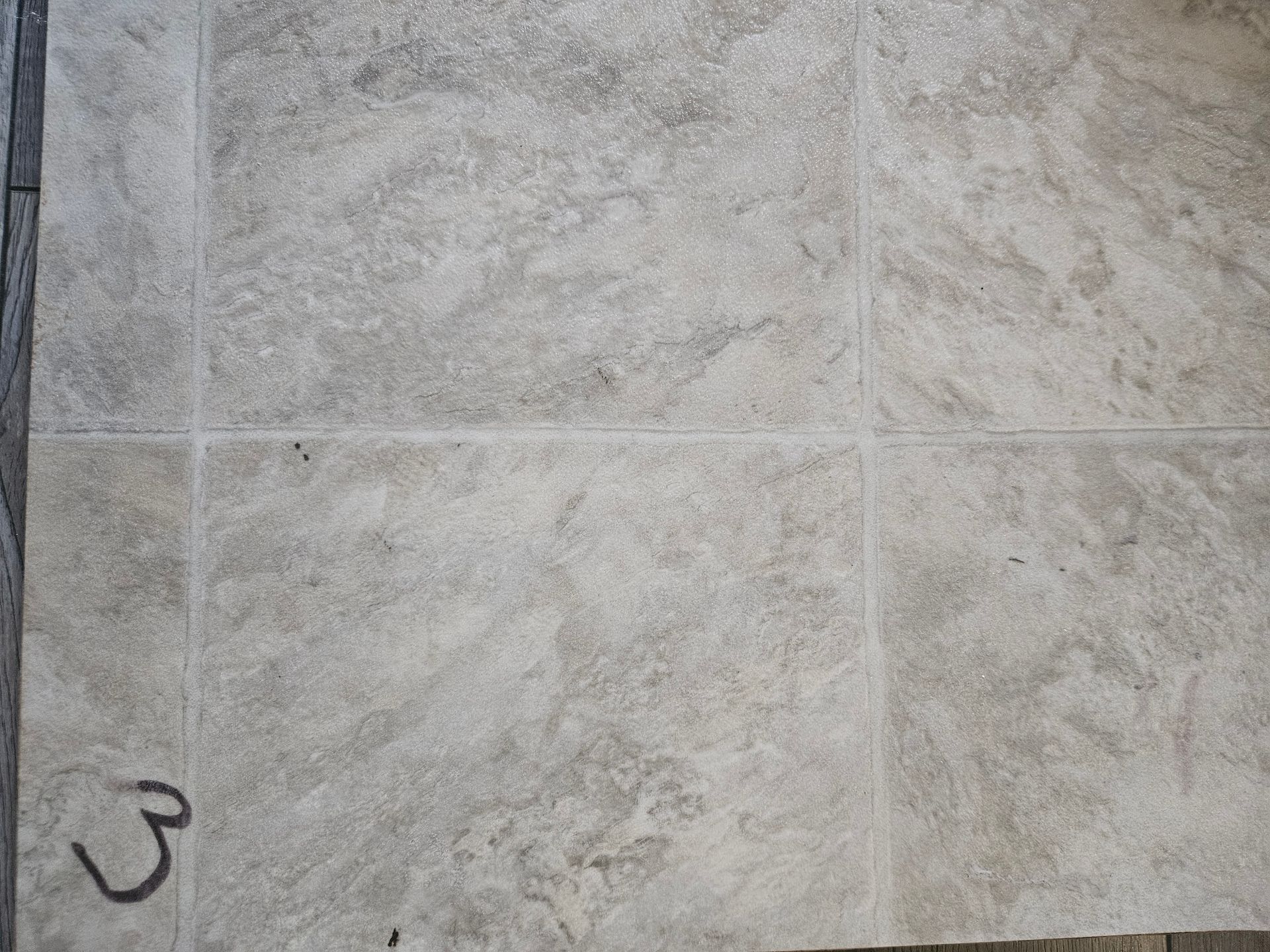 A close up of a tile floor with the number 3 on it.