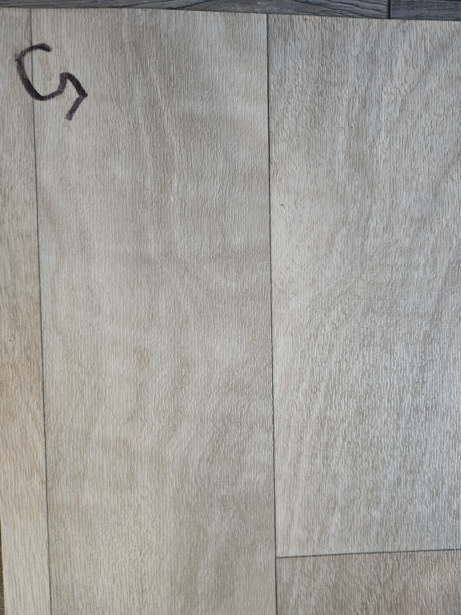 A close up of a tile floor with a letter g on it.