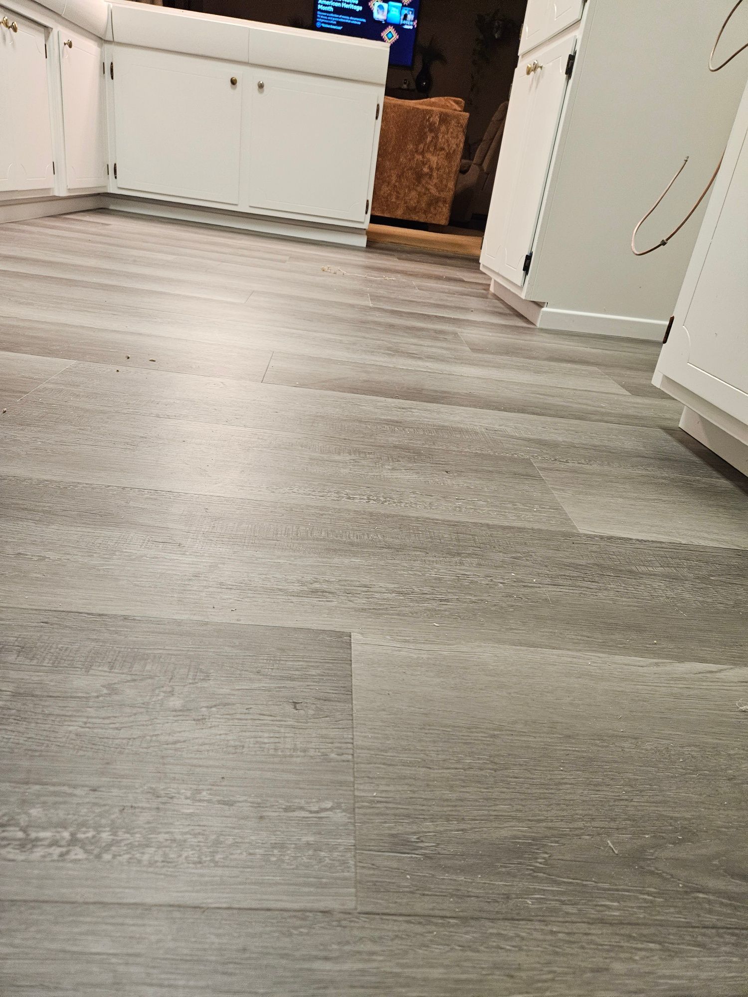 A kitchen with a wooden floor and white cabinets.