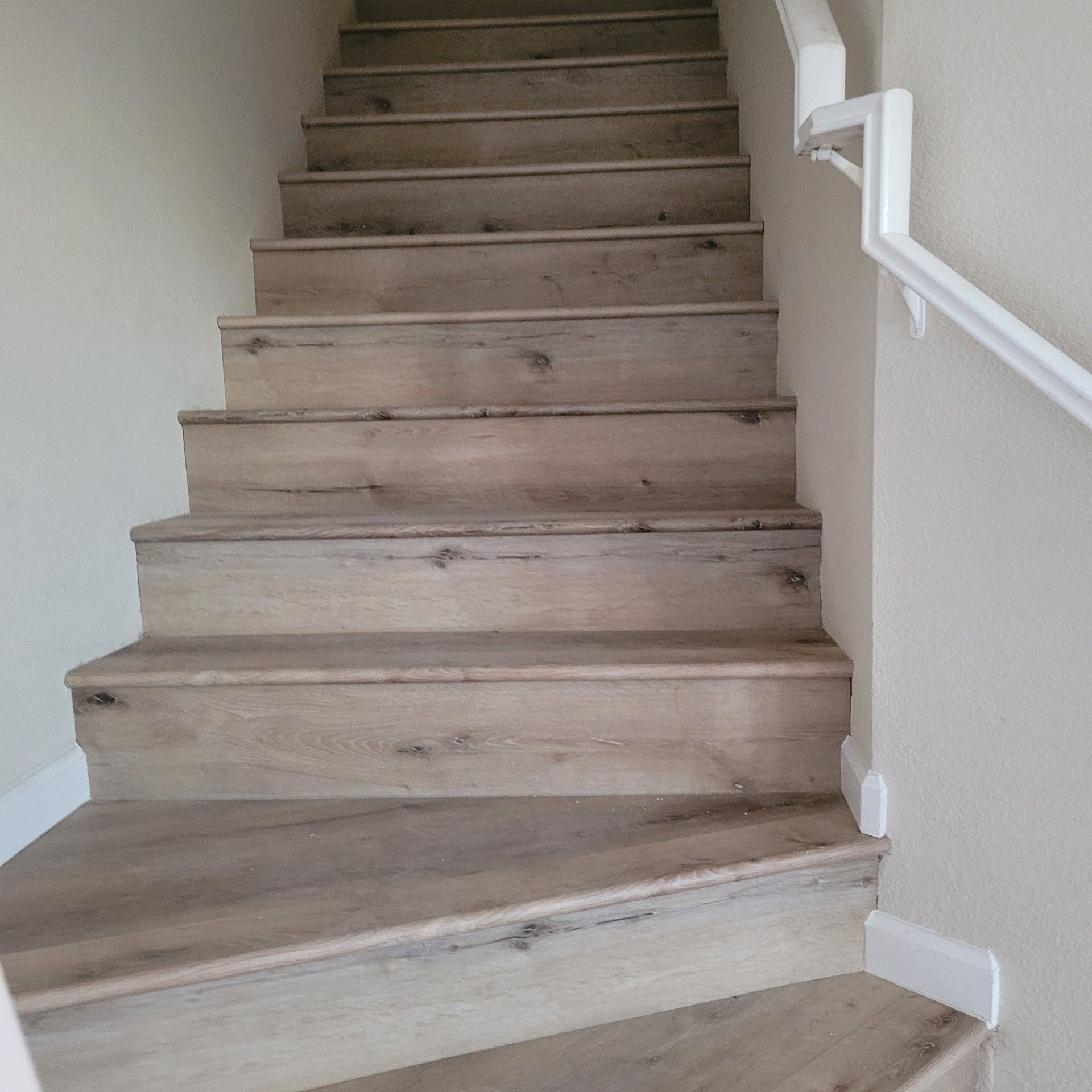 The stairs are made of wood and have a white railing.