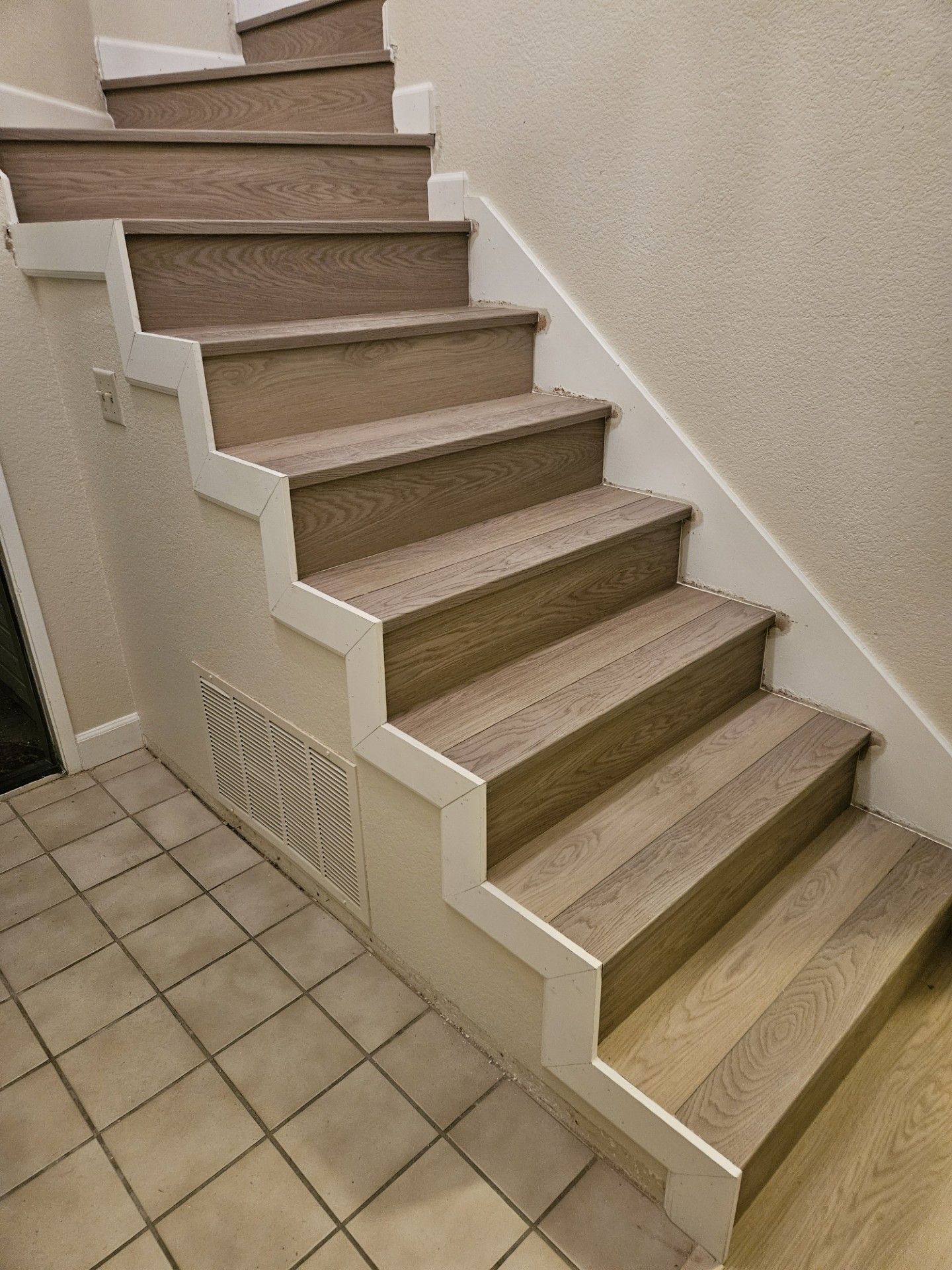 The stairs are made of wood and have a white railing.